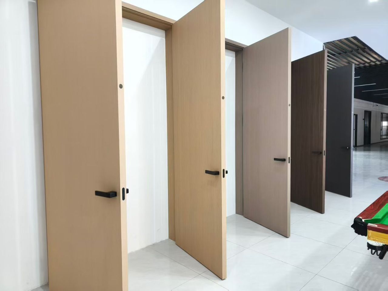 A row of ANASA doors in oak, walnut and graphite finishes standing open in the showroom